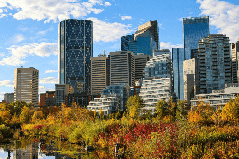 Calgary Alberta downtown skyline in autumn with vibrant fall foliage along the Bow River, home base for PCe Solutions local managed IT services and cybersecurity support across the Calgary business community.